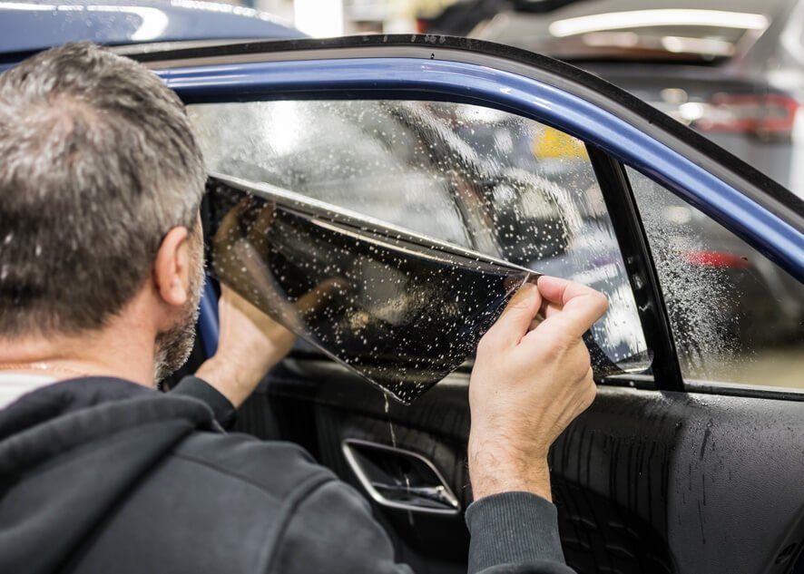 Tints Pro installer fitting window film to a car door